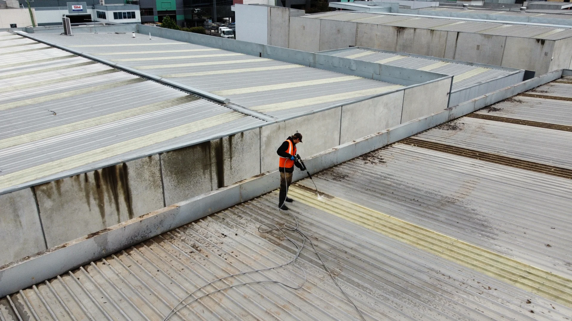 Technician cleaning a commercial factory roof