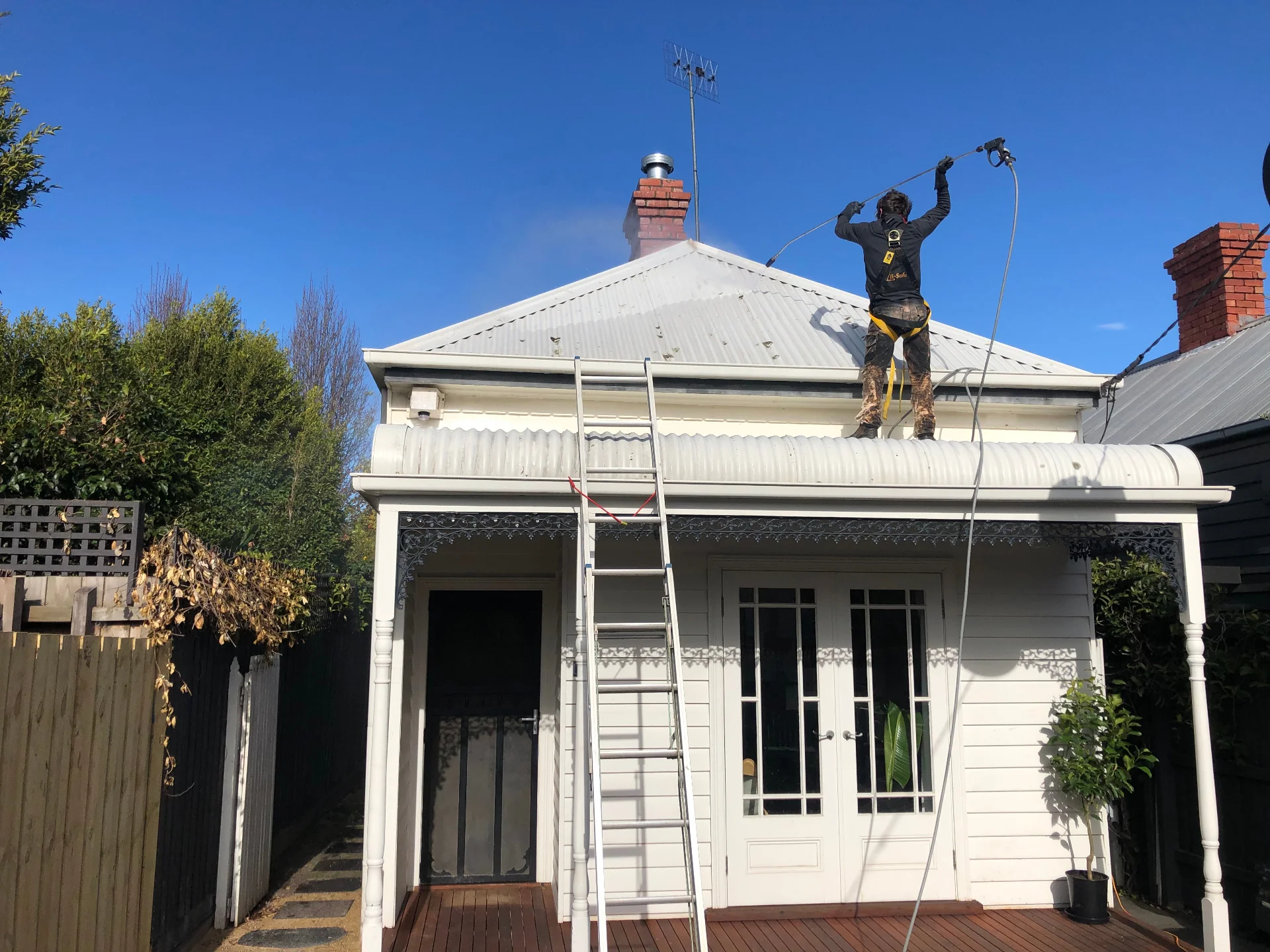 Technician on a heritage Melbourne roof pressure cleaning